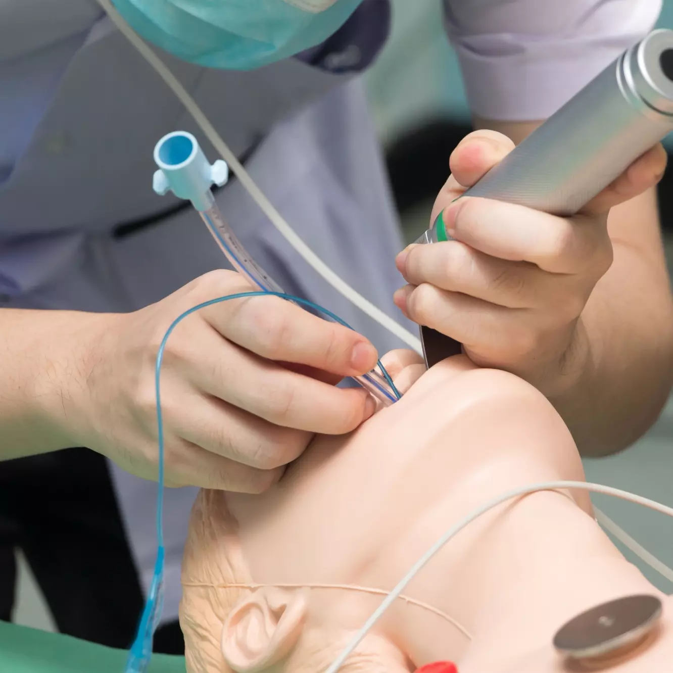 Ein Praktikant übt an einer Puppe die Intubation.