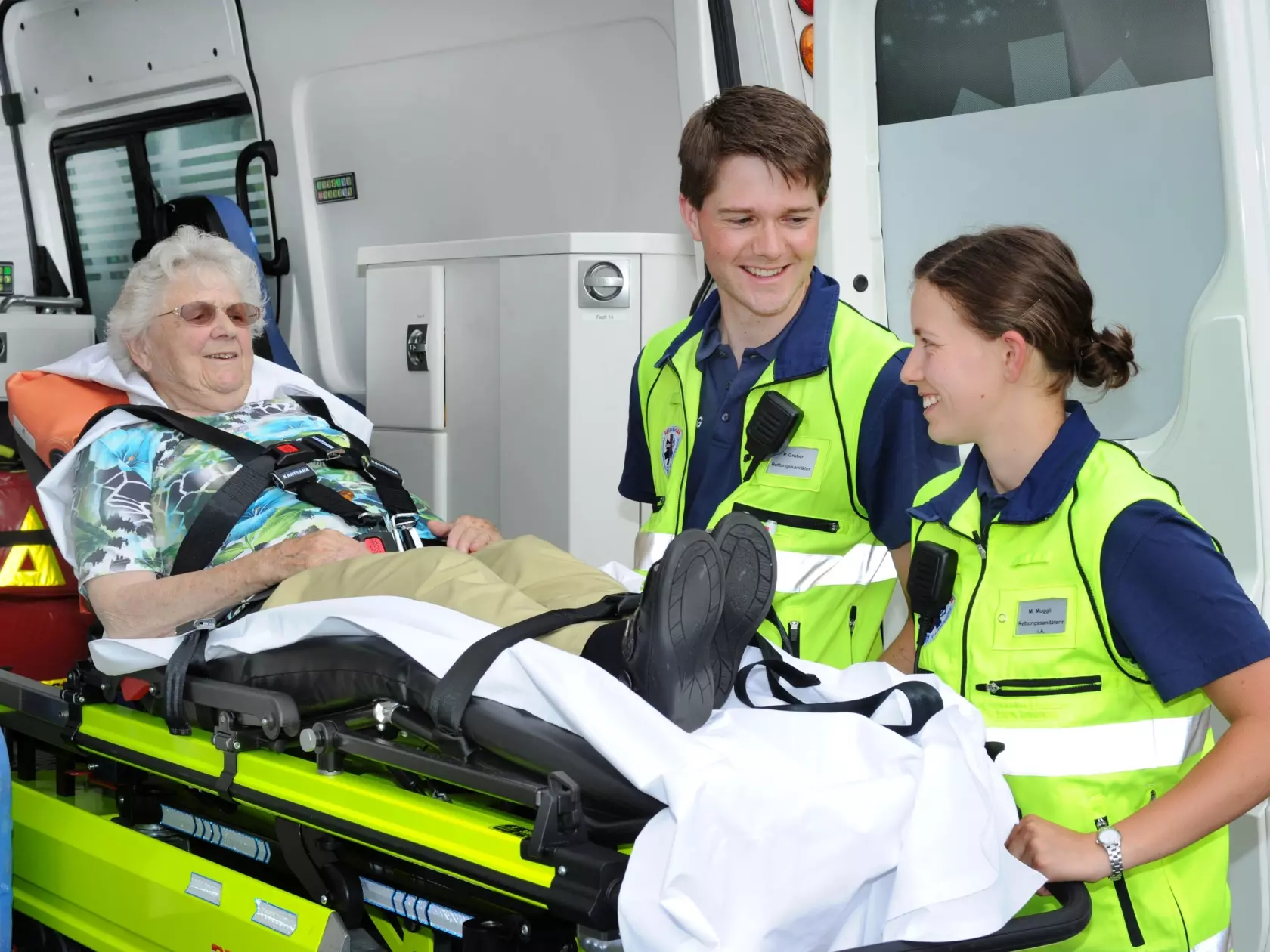 Zwei Rettungssanitäterinnen mit einer Patientin. 