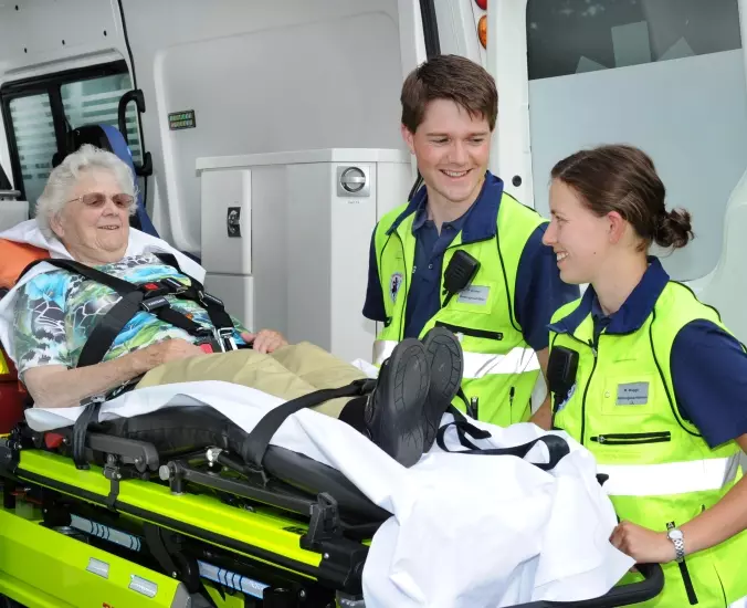 Zwei Rettungssanitäterinnen mit einer Patientin. 